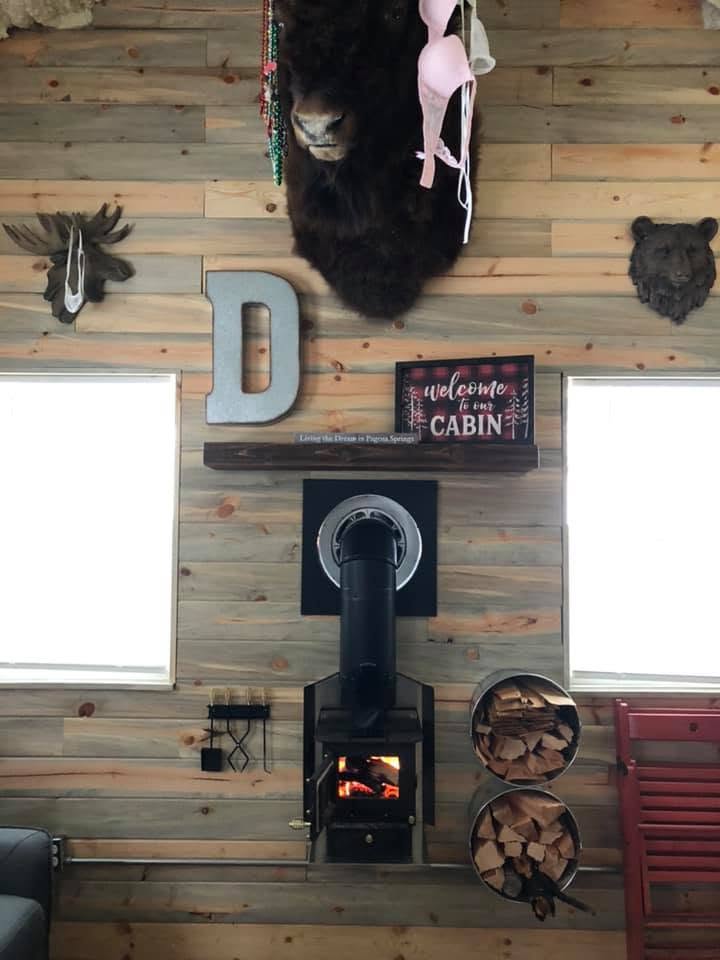 Pine wall with mounted bison, moose and bear decor above the wood stove