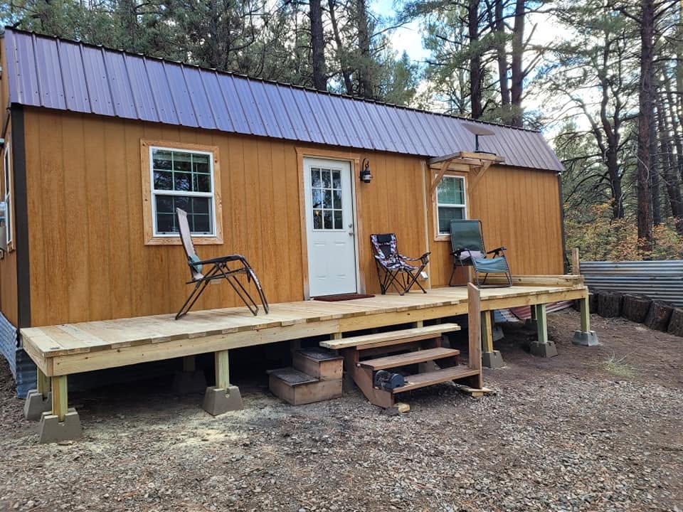 The cabin with its long front deck under ponderosa pines