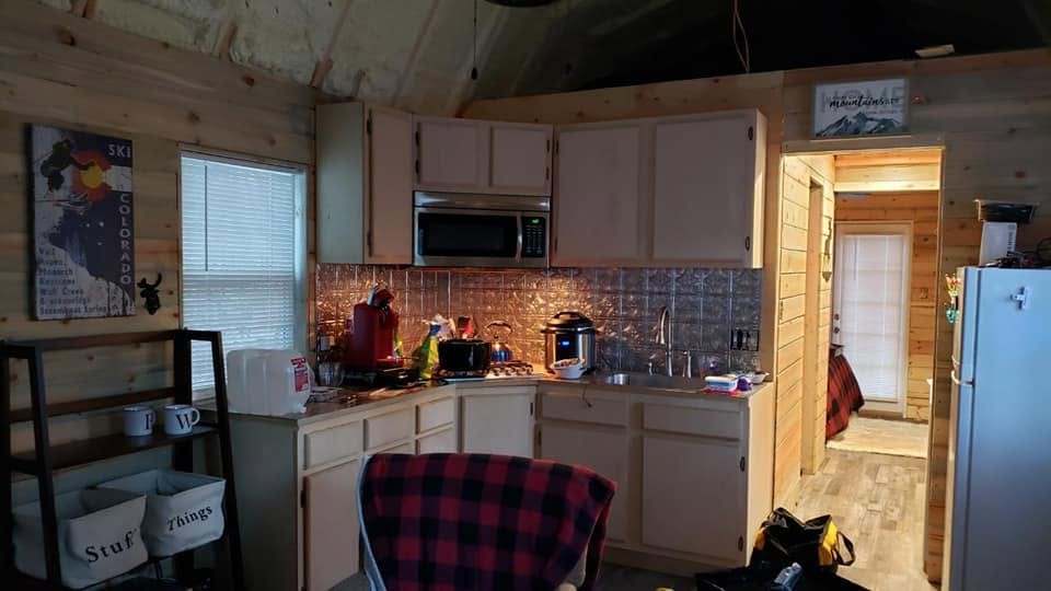 Cabin kitchen with tin backsplash and full-size fridge