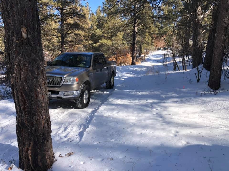 Truck parked on the snowy forest road up to the cabin