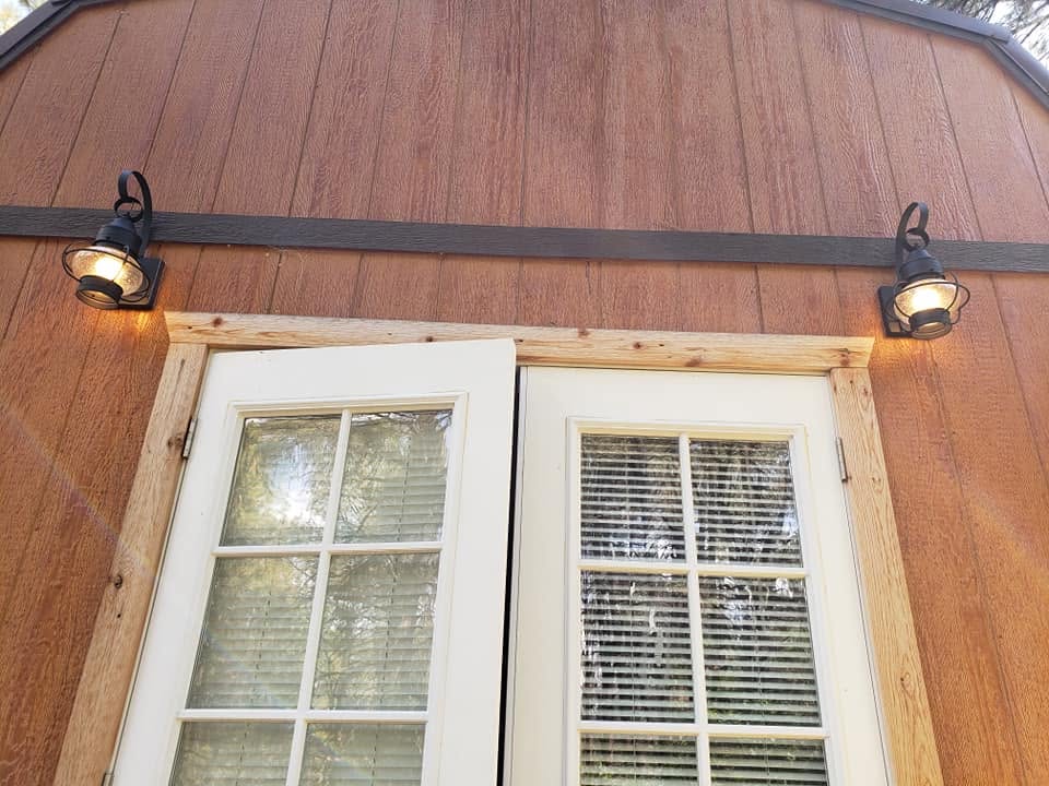 French doors off the bedroom with lantern sconces leading to the deck